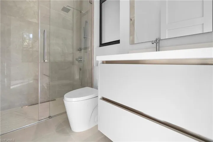 Full bathroom with vanity, a stall shower, and tile patterned floors