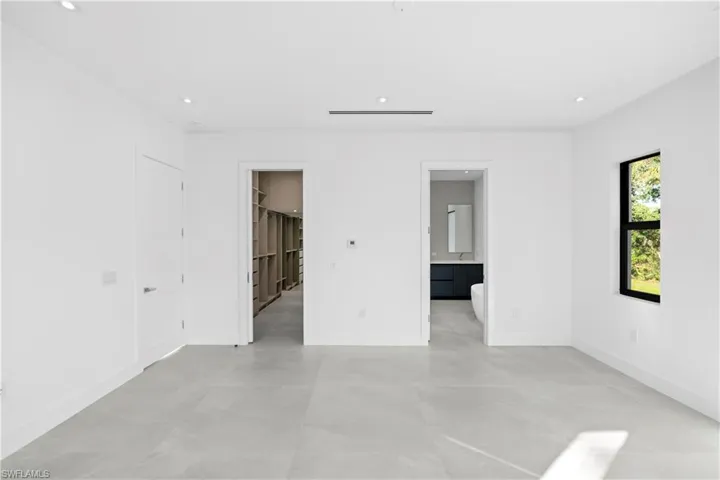 Unfurnished bedroom featuring connected bathroom and recessed lighting