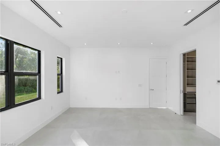 Empty room with recessed lighting and concrete flooring