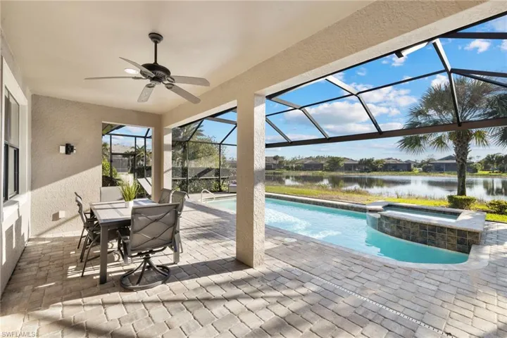View of swimming pool featuring a patio, glass enclosure, a sunroom, a pool with connected hot tub, and ceiling fan