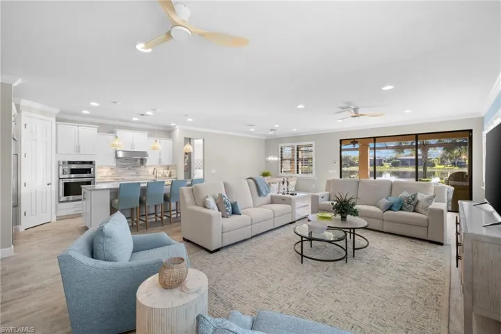 Living area featuring ornamental molding, light wood-style floors, ceiling fan, and recessed lighting