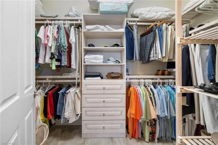 Primary Walk in closet with wood finished floors