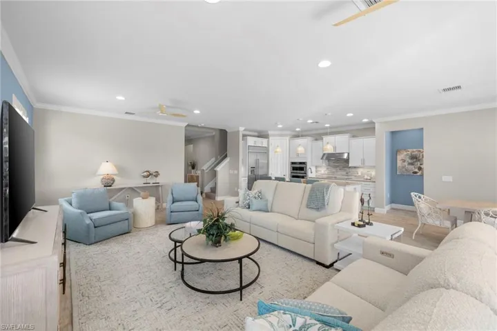 Living area featuring ornamental molding, recessed lighting, a ceiling fan, stairway, and light wood-type flooring