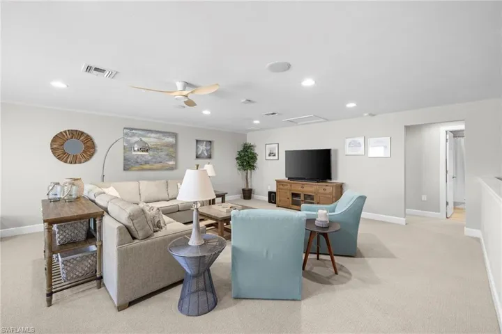 Living room with light colored carpet, recessed lighting, ceiling fan, and attic access
