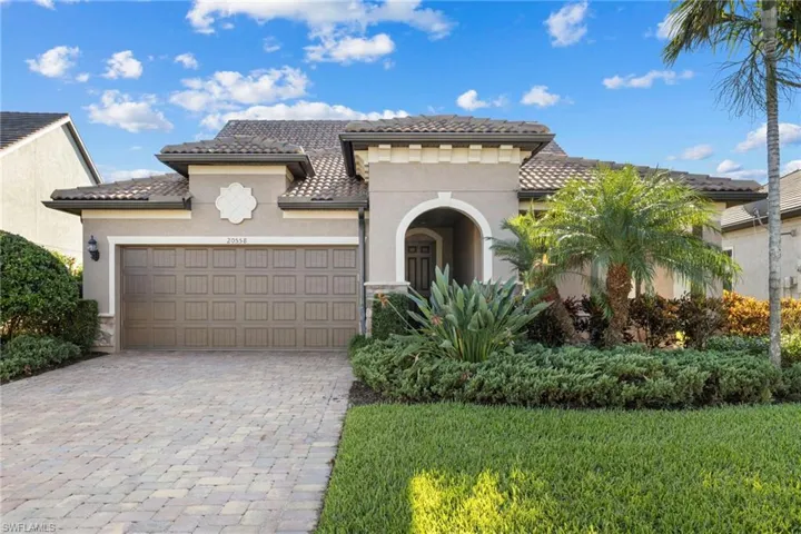 Mediterranean / spanish-style house featuring stucco siding, a tile roof, decorative driveway, an attached garage, and a front lawn