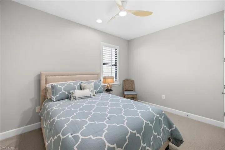 Bedroom with light colored carpet and ceiling fan