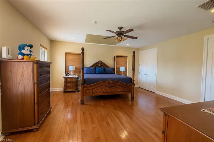 Bedroom featuring light wood finished floors, ceiling fan, and recessed lighting