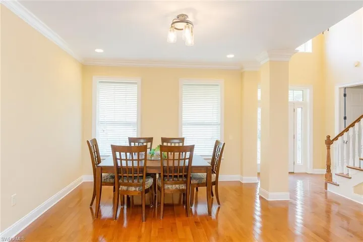 Dining room with light wood-type flooring, stairway, and ornamental molding