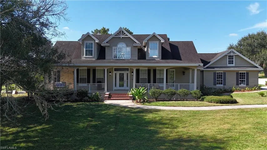 View of front of house with a porch, a front lawn, and a shingled roof