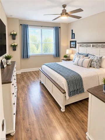 Wood-finish flooring throughout, ceiling fan with integrated lighting, and window with blinds