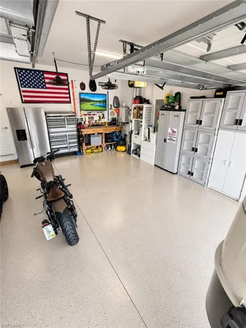 Coated garage flooring with track lighting and overhead storage racks