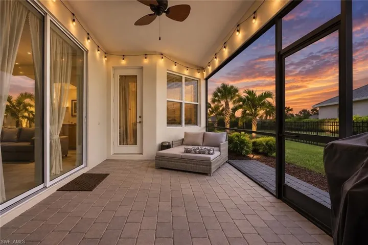 Screened-in patio with paver flooring, overhead string lighting, and ceiling fan