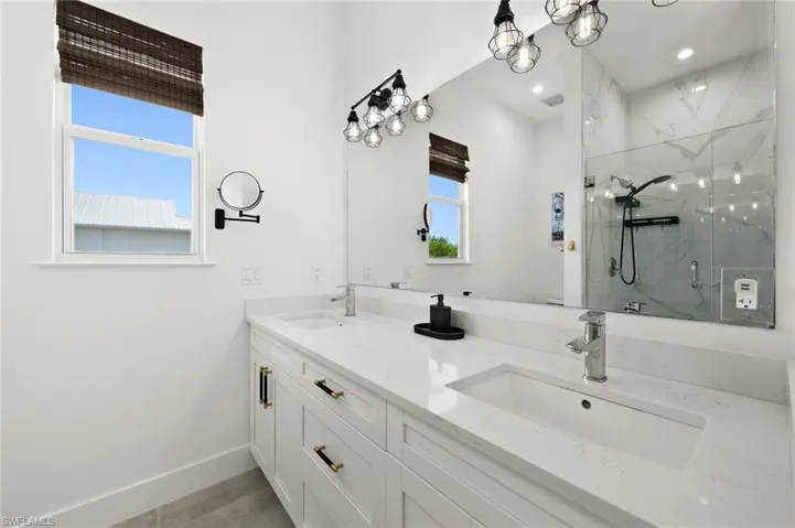 Bathroom featuring plenty of natural light, walk in shower, and vanity