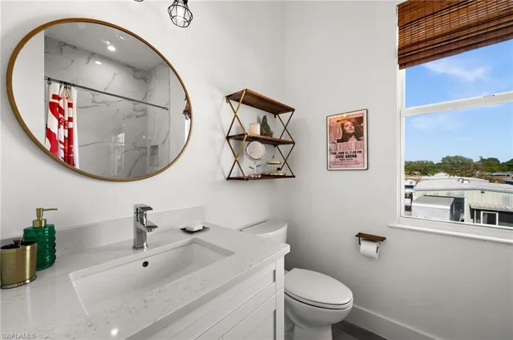 Bathroom with a shower with curtain, vanity, and toilet