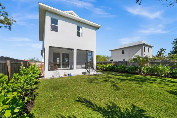 Rear view of property with a sunroom and a yard