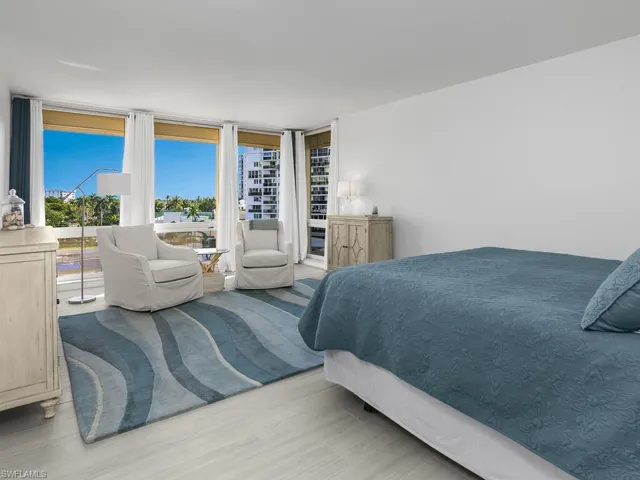 Bedroom featuring floor to ceiling windows, wood finished floors, and access to outside