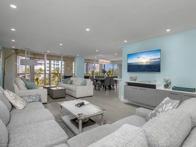 Living area with floor to ceiling windows, light wood-type flooring, and recessed lighting