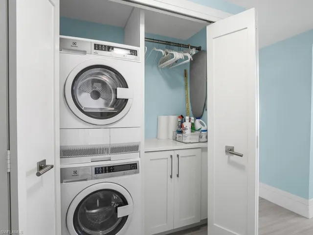 Laundry area featuring estacked washer and dryer and light wood finished floors