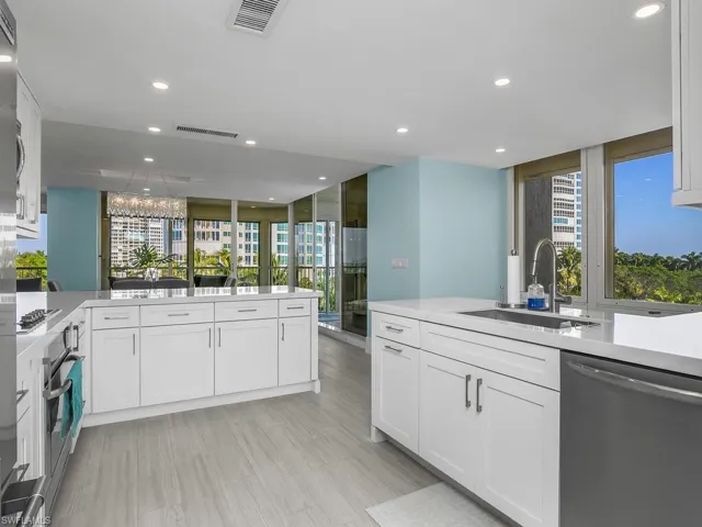 Kitchen featuring appliances with stainless steel finishes, white cabinets, a peninsula, plenty of natural light, and recessed lighting