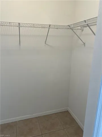 Walk in closet with light tile patterned flooring