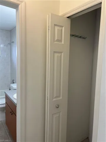 Bathroom with vanity, toilet, tile patterned floors, and shower / washtub combination