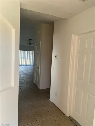 Hall featuring tile patterned flooring and baseboards