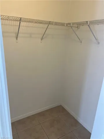 Spacious closet with light tile patterned floors