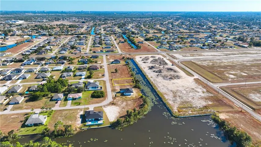Aerial overview of property's location with a large body of water and nearby suburban area