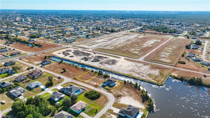 Aerial view of property's location with a nearby body of water and nearby suburban area