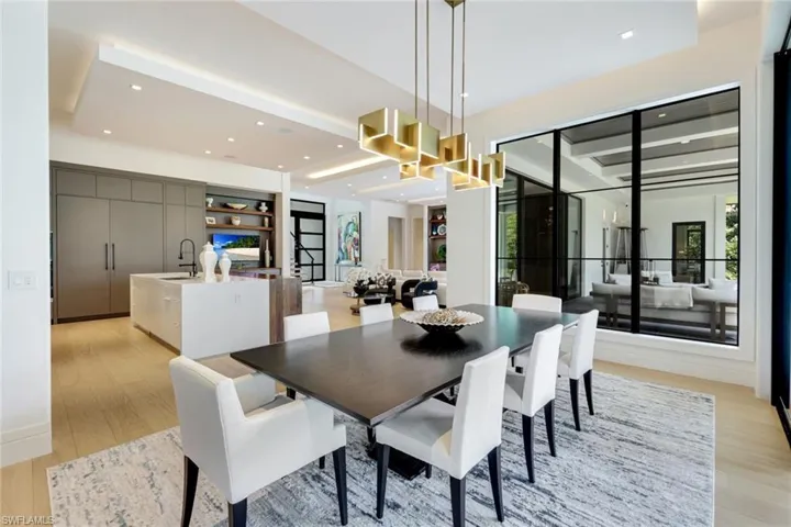 Dining area with light wood finished floors and recessed lighting