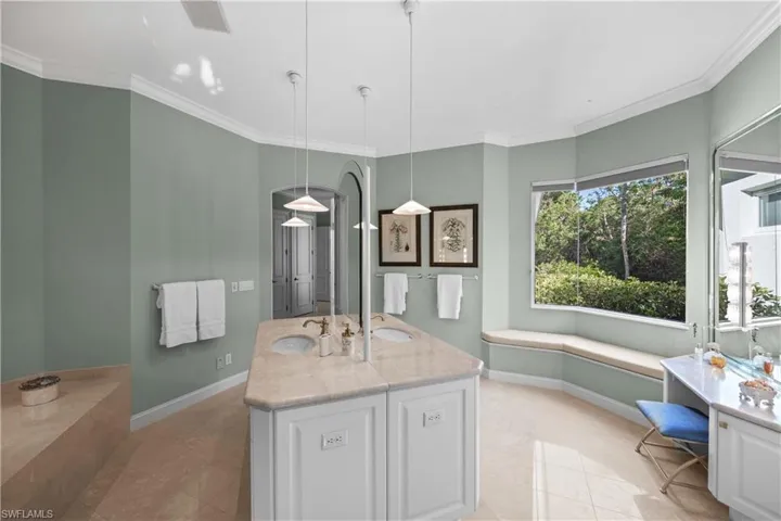 Bathroom featuring tile patterned flooring, vanity, and ornamental molding