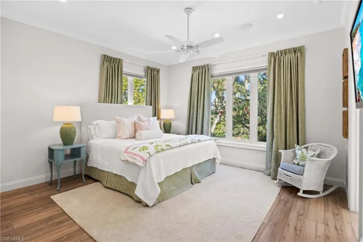 Bedroom featuring hardwood / wood-style floors, ceiling fan, and ornamental molding