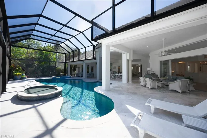 View of swimming pool featuring an outdoor living space, glass enclosure, ceiling fan, an in ground hot tub, and a patio