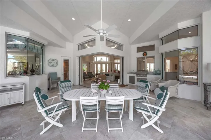 Dining room with ceiling fan, a textured ceiling, and high vaulted ceiling