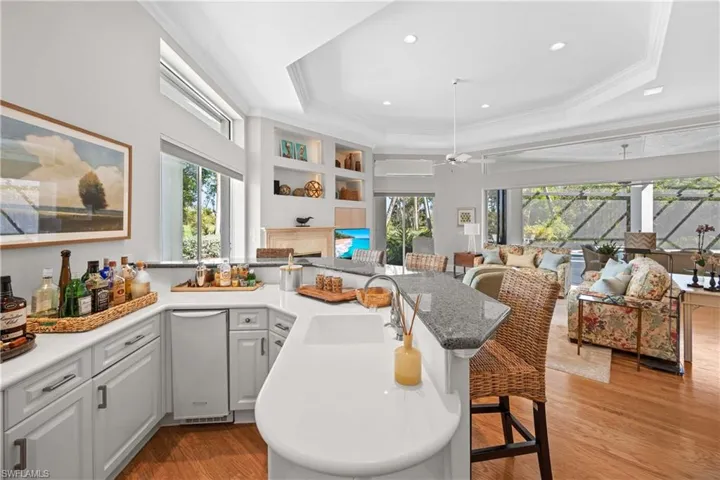 Kitchen with a raised ceiling, sink, light hardwood / wood-style flooring, ceiling fan, and ornamental molding