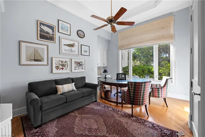 Living room featuring ceiling fan, hardwood / wood-style floors, and ornamental molding