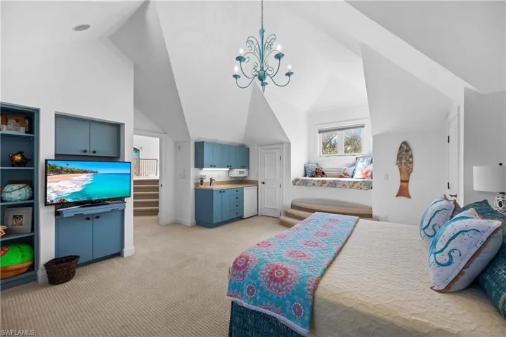 Bedroom featuring high vaulted ceiling, light colored carpet, and an inviting chandelier