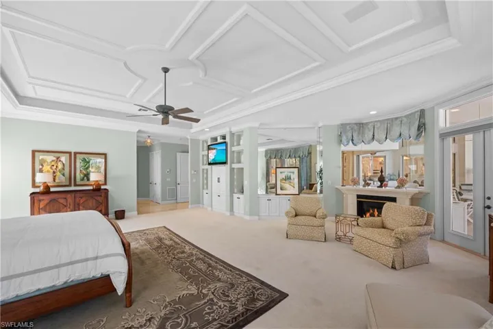 Carpeted bedroom with access to outside, ceiling fan, crown molding, and coffered ceiling