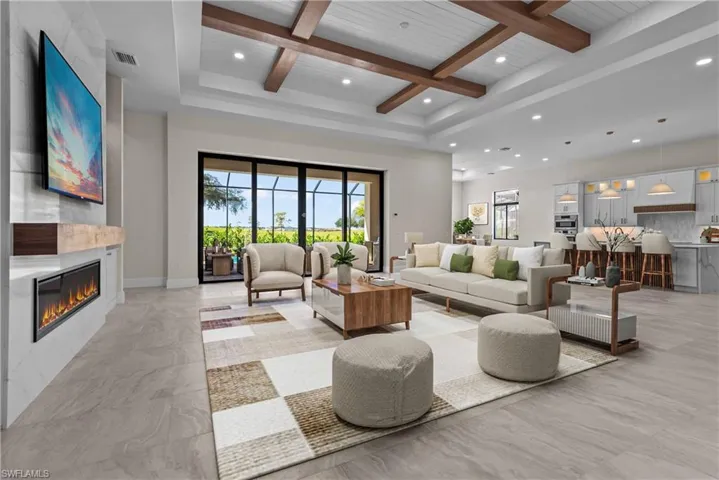 Living area with healthy amount of natural light, coffered ceiling, recessed lighting, a large fireplace, and a wooden ceiling with exposed beams