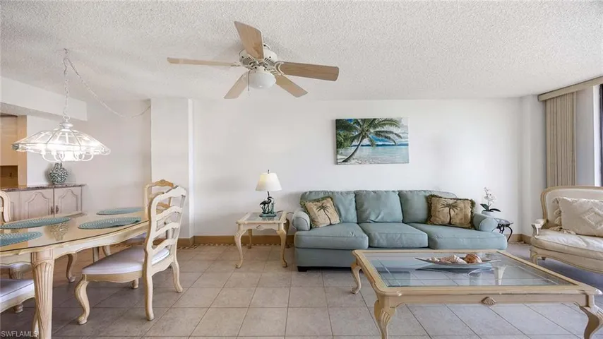 Tiled living room with a textured ceiling and a ceiling fan