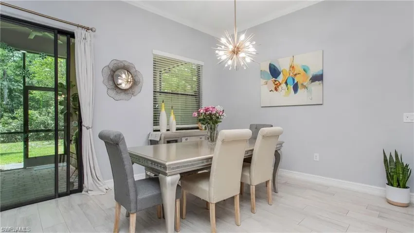 Dining room featuring a chandelier, ornamental molding, and wood finished floors
