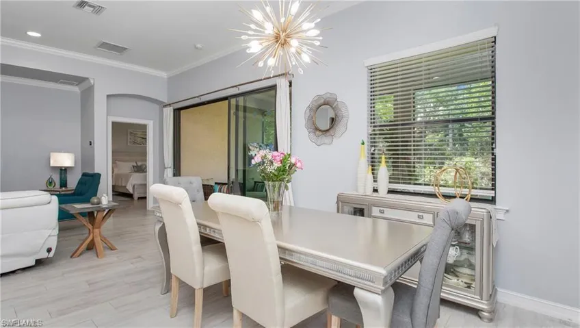 Dining room featuring a chandelier, ornamental molding, light wood-style flooring, and recessed lighting