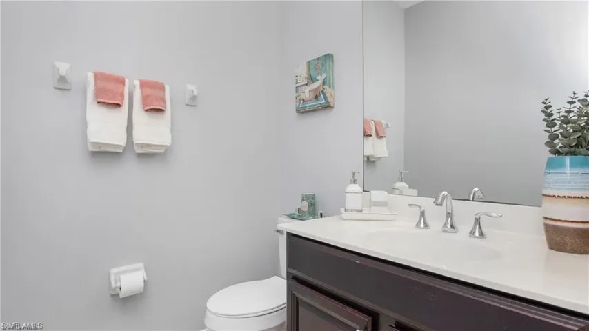 Half bathroom featuring vanity and toilet