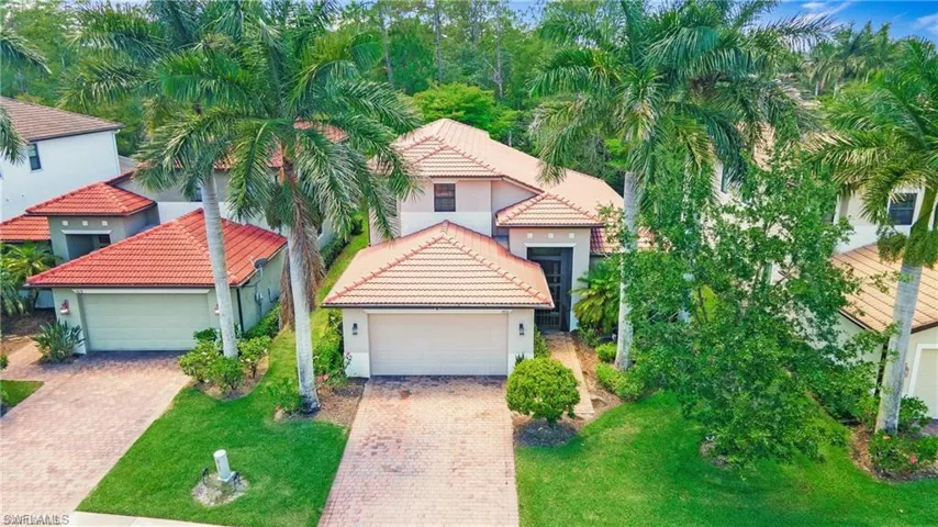 View of front of home with a tile roof, stucco siding, and a front lawn