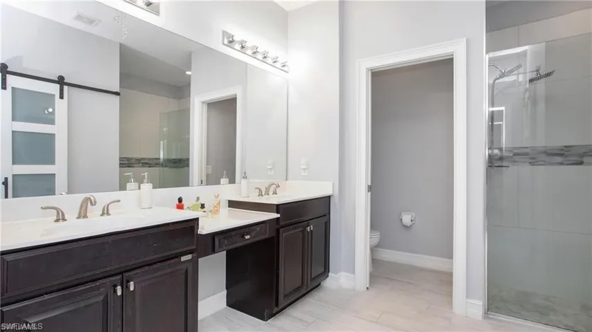 Full bath with a stall shower and double vanity