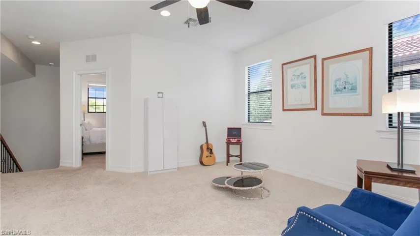 Living area with healthy amount of natural light, carpet flooring, a ceiling fan, and recessed lighting