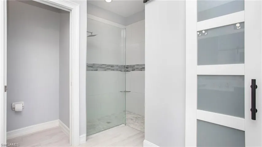 Bathroom featuring tiled shower and wood finished floors