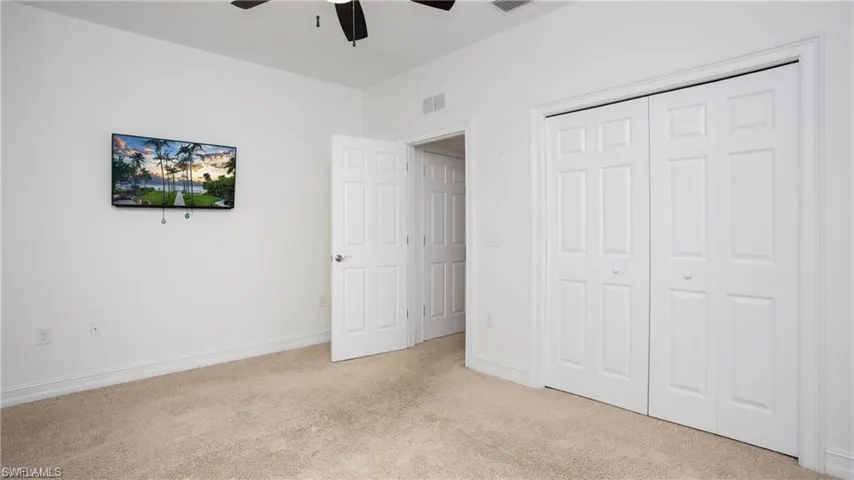 Unfurnished bedroom featuring carpet flooring, a closet, and ceiling fan