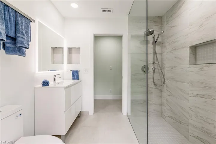 Full bathroom featuring walk in shower, vanity, recessed lighting, and access to outdoor area