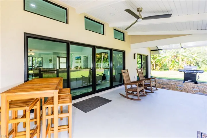 View of screened patio featuring a grill and ceiling fan